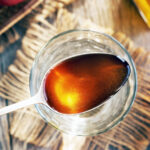 Apple,Cider,Vinegar,On,A,Metal,Spoon,Above,A,Glass